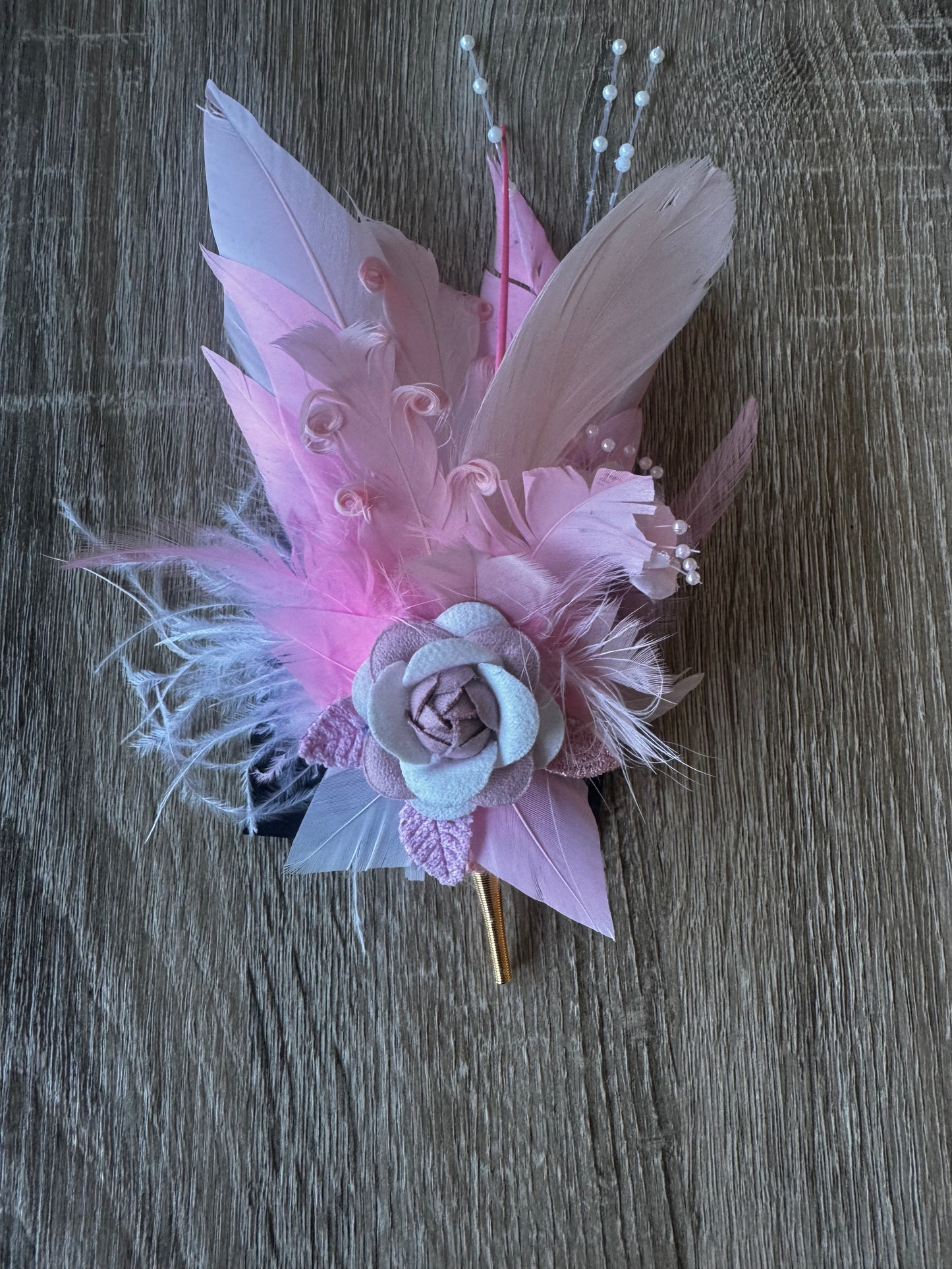 Baby pink hunter feather on a pin